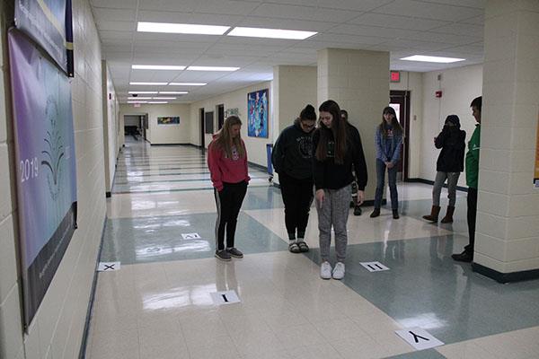 Students graphing coordinates in the hallway
