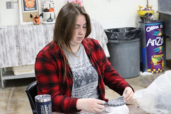 Student working in Pottery class with clay
